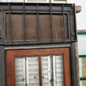 Puerta de madera con banderola con reja vidrio partido