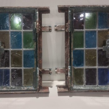 Dos pequeñas ventanas vitreaux de una hoja de abrir con tapa metálica